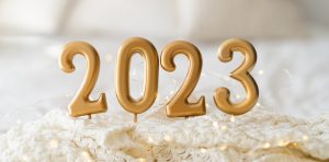Happy New Years 2023. Christmas background with 2023 candles and white knit sweater.